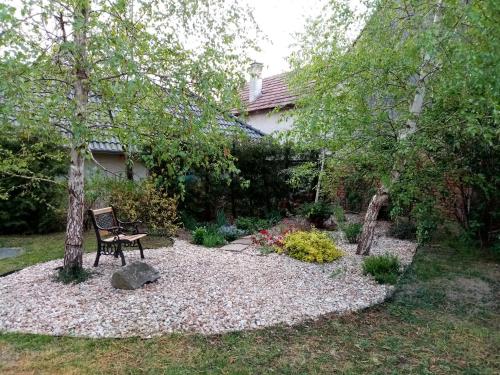 a garden with a bench in the middle of a yard at Kőszeghegyalja Vendégház in Horvátzsidány
