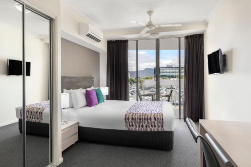 a hotel room with a bed and a balcony at Park Regis City Quays in Cairns