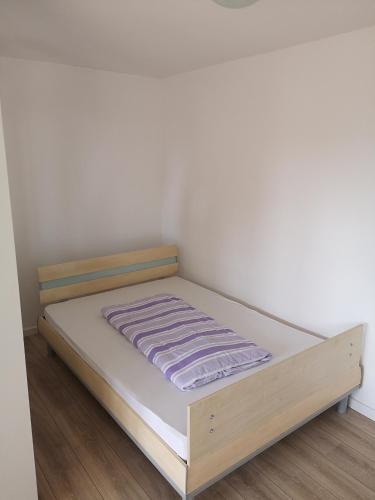 a bed in a room with a white wall at Wohnlich in Würselen