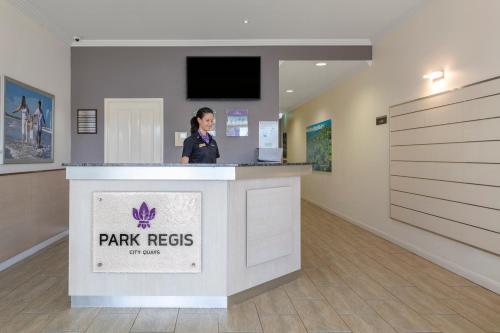 a woman standing at a counter in a room at Park Regis City Quays in Cairns