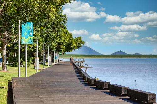 a person walking down a wooden boardwalk next to a lake at Piermonde Apartments Cairns in Cairns