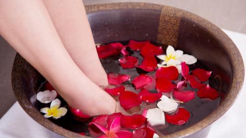 a person with their foot in a bowl filled with flowers at The Mangrovetree Sanya Resort in Sanya