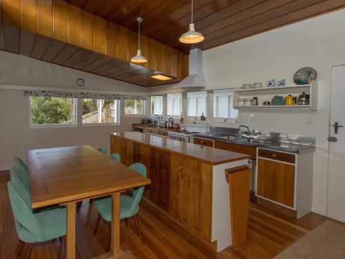 a kitchen with a wooden counter and a wooden table at Sixties Cedar Bach - Kuratau Holiday Home in Kuratau