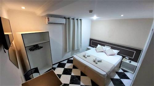 a small room with a bed and a checkered floor at Hotel Golden Vilage Vila Maria in São Paulo
