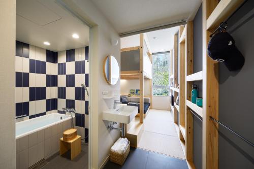 La salle de bains est pourvue d'un lavabo et d'une baignoire. dans l'établissement Hoshino Resorts BEB5 Karuizawa, à Karuizawa
