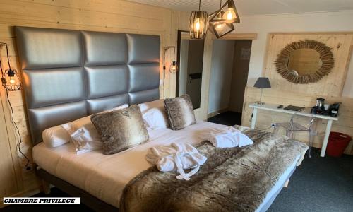 a bedroom with a large bed with towels on it at Hotel Le Panorama in Le Mont-Dore