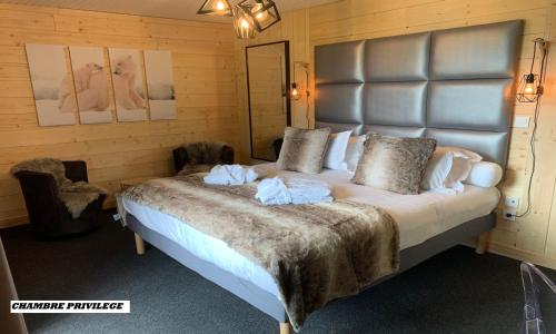 a bedroom with a large bed with towels on it at Hotel Le Panorama in Le Mont-Dore