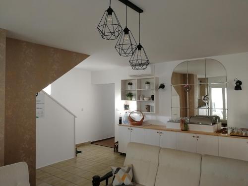 a kitchen with white cabinets and a large mirror at Kathy Panzió in Balatongyörök