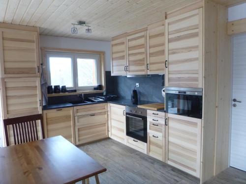 a kitchen with wooden cabinets and a wooden table and a table sidx sidx at L Ame et Son du Coeur in Dorénaz