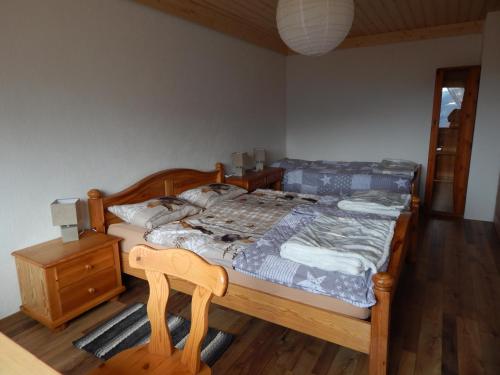 a bedroom with a wooden bed and a wooden chair at L Ame et Son du Coeur in Dorénaz