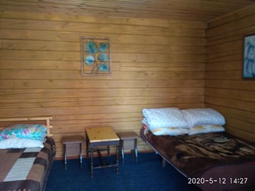 ボリショエ・ゴロウストノエにあるChastnaya Usadba Stanitsaのベッド2台とテーブルが備わる客室です。