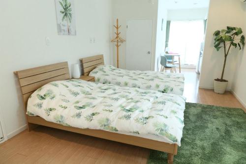 a bedroom with a bed and a green rug at Mkグリーンホテル in Kawaguchi