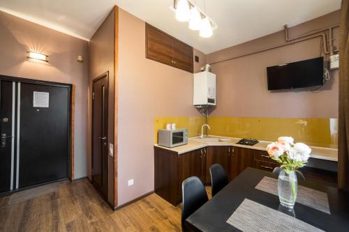 a kitchen and dining room with a table and a microwave at Апартаменти з сучасним ремонтом на площі Митній in Lviv