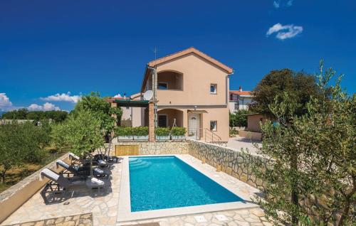 a villa with a swimming pool in front of a house at Holiday apartment Boko in Pinezici