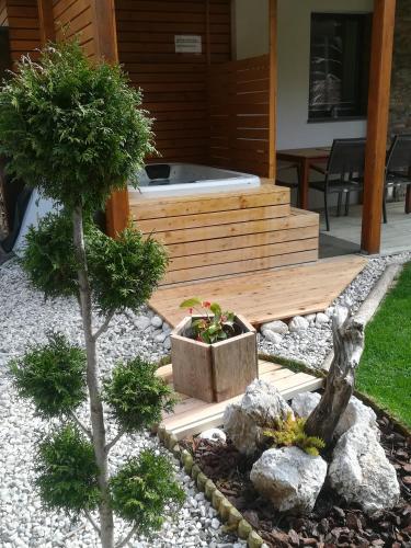 a garden with a jacuzzi tub and a tree at Hiša Katja-Privat wellness in Kranjska Gora