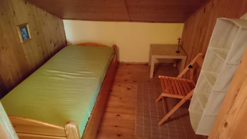 a small room with a bed and a chair at Otomiński Relaks in Gdańsk