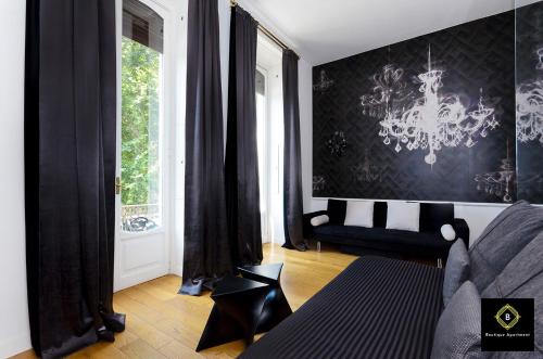 Boutique Apartment Glamour Torino في تورينو: غرفة معيشة مع أريكة وثريا
