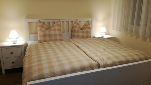 1 dormitorio con 1 cama con almohadas y 2 lámparas en Ferienwohnung Luba Lipa, en Drachhausen