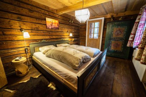 a bedroom with a bed in a log cabin at Landhaus Alpentraum in Kaning