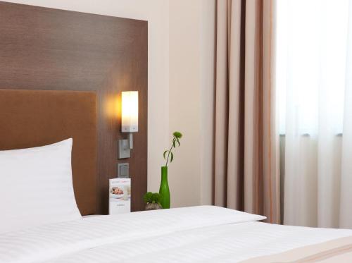 Кровать или кровати в номере IntercityHotel Hannover