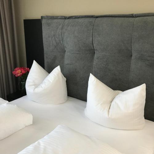 two white pillows on a bed with a headboard at ROSS Hotel nähe Messe Stuttgart in Stuttgart
