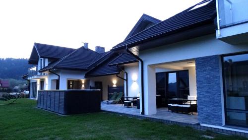 a house with a patio in the yard at DOMINO-APARTAMENTY Blue in Krościenko