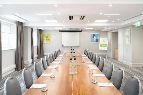 a conference room with a long table and chairs at Holiday Inn Hemel Hempstead M1, Jct. 8 by IHG in Hemel Hempstead