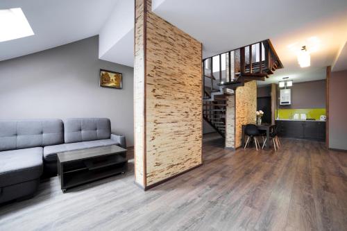 ein Wohnzimmer mit einem Sofa und einer Holzwand in der Unterkunft Apartments on Mitny Square in Lwiw