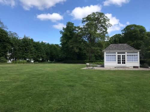 a picnic shelter in the middle of a large grass field at Het Witte Kasteel in Loon op Zand