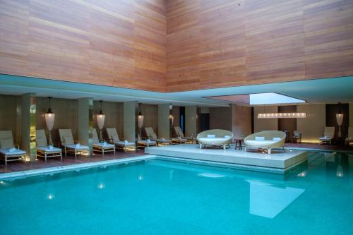 uma piscina num hotel com cadeiras e mesas em Grand Hyatt Chengdu em Chengdu