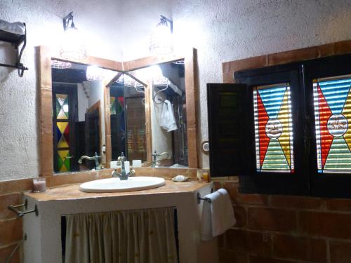 ein Badezimmer mit einem Waschbecken und Buntglasfenstern in der Unterkunft Casa Rural Castillo LA Iruela in La Iruela