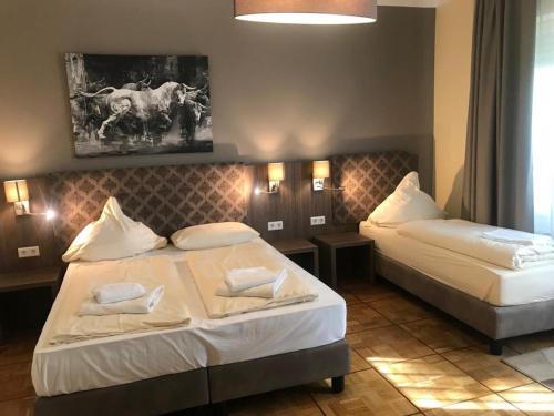 una habitación de hotel con 2 camas y un cuadro en la pared en Hotel Il Cavallino, en Warendorf