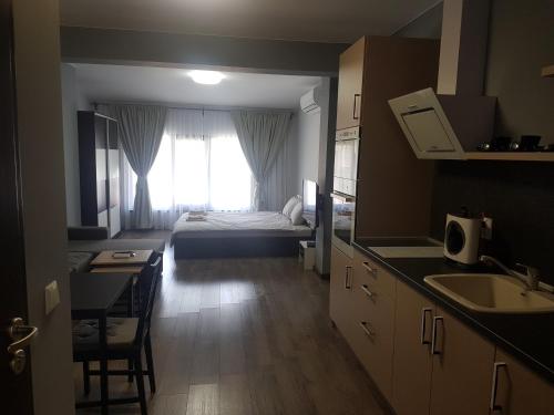 a room with a bed and a kitchen with a sink at LUXURY SUITES 3 in Karlovo