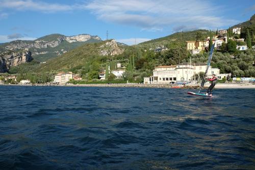 a person is windsurfing on a body of water at Hotel Paradiso Conca d'Oro in Nago-Torbole