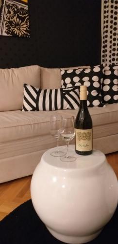 a bottle of wine on a table with two wine glasses at Apartman Tufna in Užice