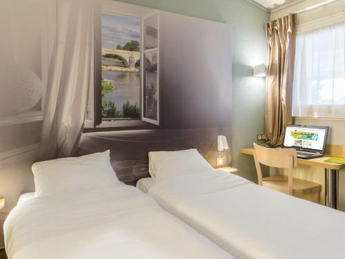 um quarto de hotel com duas camas e uma secretária com um computador em B&B HOTEL Bordeaux Le Haillan em Le Haillan