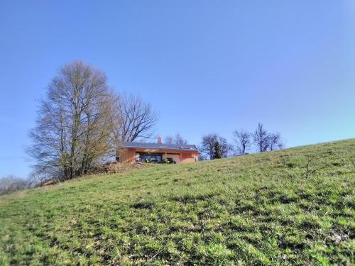 une maison assise au sommet d'une colline herbeuse dans l'établissement Jagdhaus im Grünen, mit Sauna, à Kulmbach