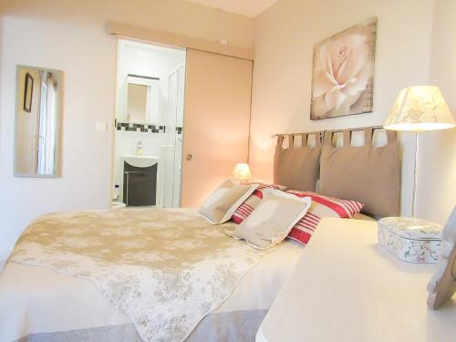 1 dormitorio con 1 cama, 1 mesa y 1 lámpara en Cabourg, cosy appartement avec balcon + parking privé, en Cabourg