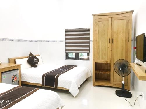 a bedroom with two beds and a television in it at Hoa Trang Hotel in Tuy An