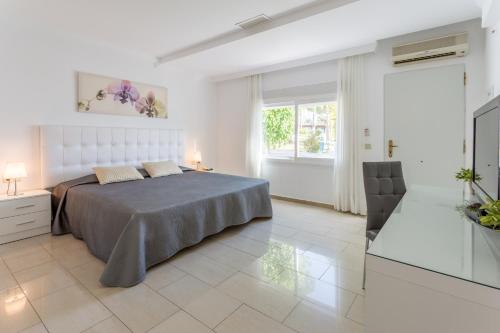 a white bedroom with a bed and a window at VIME La Reserva de Marbella in Marbella