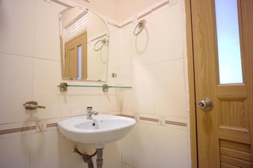 ein Bad mit einem Waschbecken und einem Spiegel in der Unterkunft OYO 987 Thanh Thanh Nhan Hotel in Da Lat
