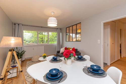 Una sala de estar con una mesa y sillas blancas. en Le petit Barclay - Appartement privé de 45 m2 - 2 a 4 personnes - Parking gratuit, en Metz