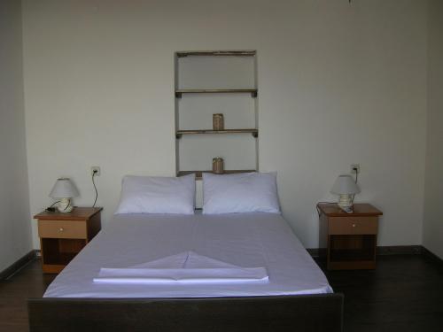 Un dormitorio con una cama con dos mesitas de noche y dos lámparas. en Villa Kastri, en Gavdos