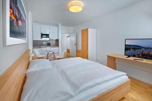 Schlafzimmer mit einem großen weißen Bett und einem Schreibtisch in der Unterkunft Downtown Suites Kodanska in Prag