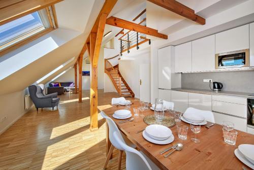 cocina y comedor con mesa de madera y sillas en Downtown Suites Kodanska, en Praga