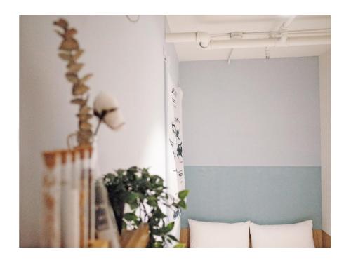 a bedroom with a blue and white wall with pillows at Paper Plane Hostel in Kaohsiung