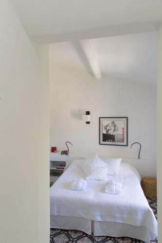- une chambre blanche avec un lit et des draps blancs dans l'établissement Villa Vagabonde, à Gordes