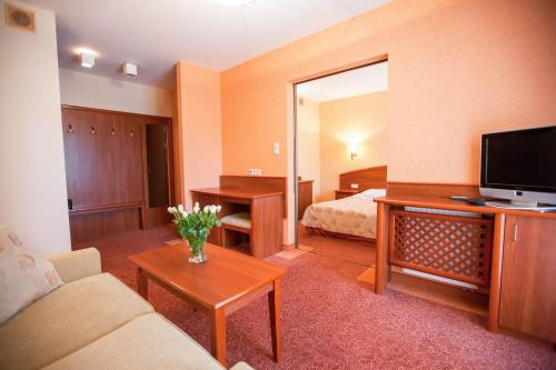 ein Hotelzimmer mit Bett und Wohnzimmer in der Unterkunft Willa Gryf in Mielno