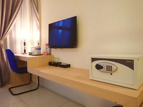 a room with a desk with a television on it at De Elements Business Hotel KL in Kuala Lumpur