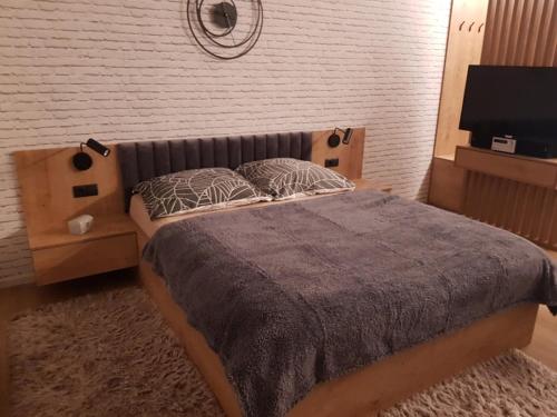 a bedroom with a large bed and a flat screen tv at Apartament green-balcony z parkingiem i rowerami in Świnoujście